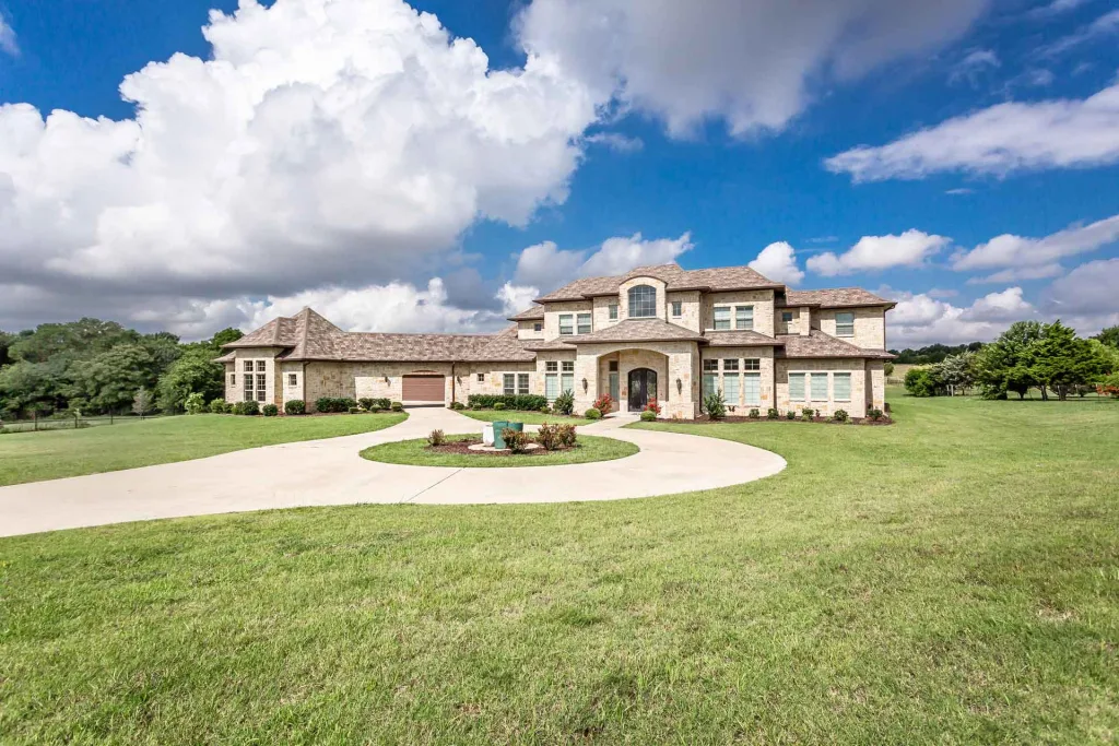 A spacious home featuring a long driveway and a beautifully maintained large yard.