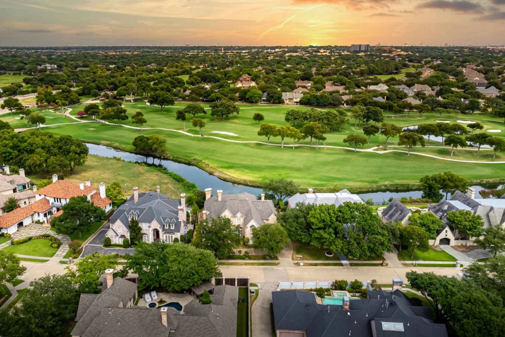 Aerial view showcasing a lush golf course surrounded by elegant houses, highlighting the beauty of the landscape
